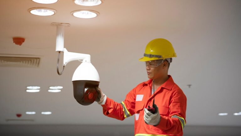 Professional installing a security camera in an office